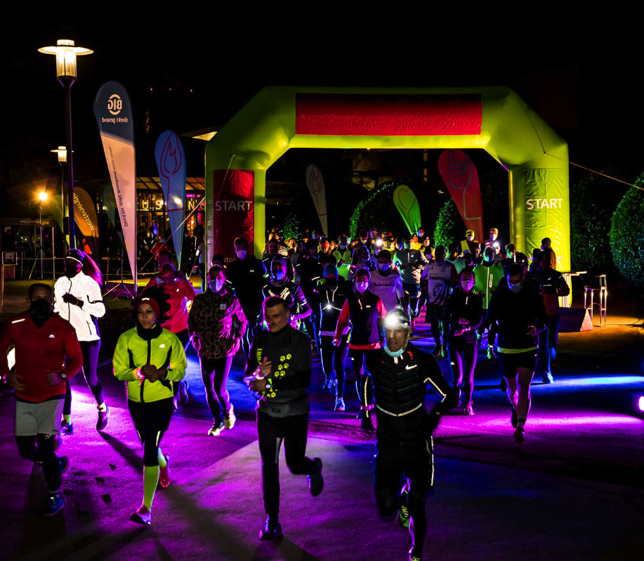 Läuferinnen und Läufer starten im beleuchteten Grugapark beim Parkleuchten RUN
